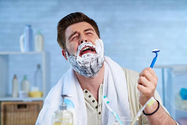 Man bursting into tear while shaving his beard